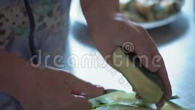 特写镜头，一位老妇人的手在一片薄木桩黄瓜的帮助下
